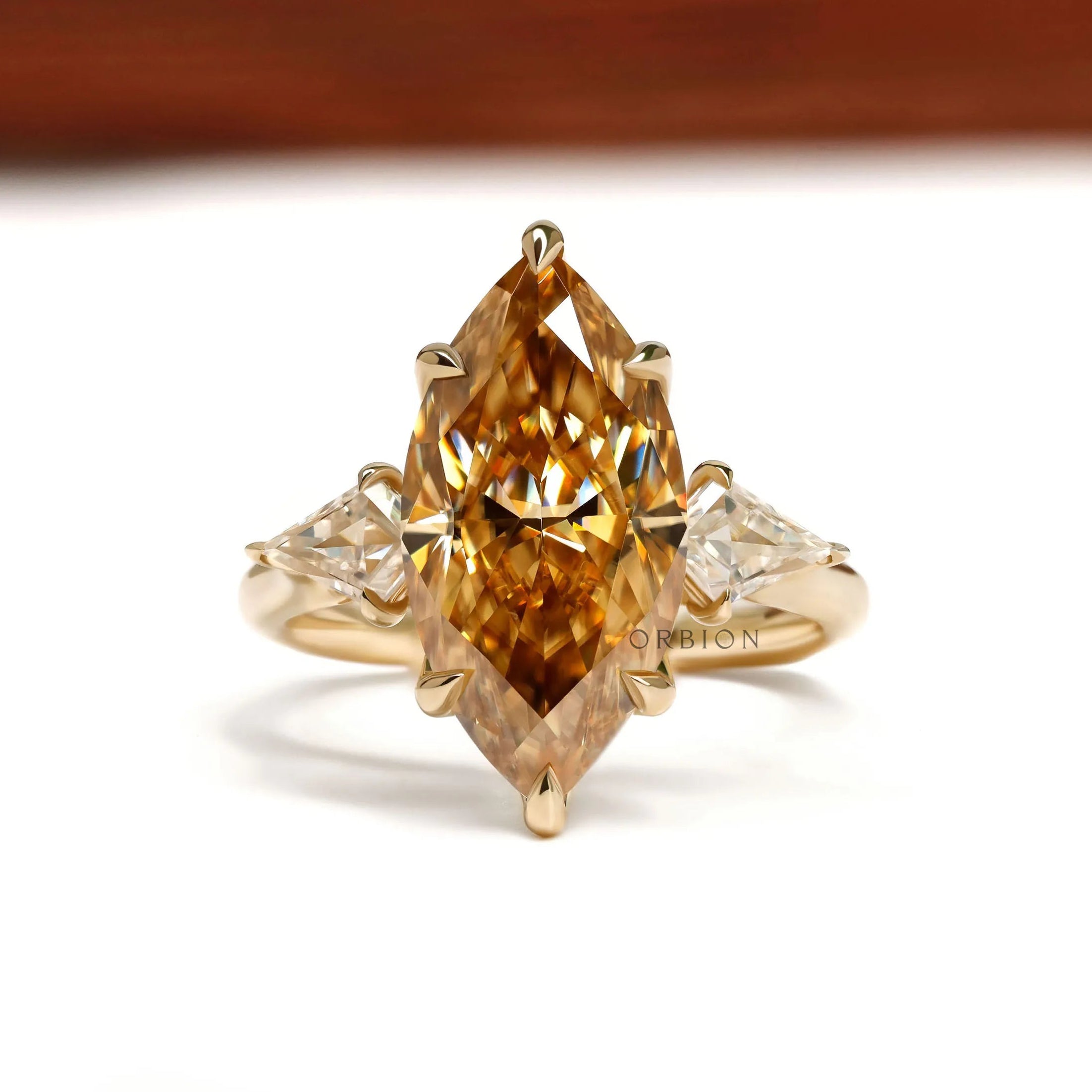 Marquise champagne three stone moissanite ring with tulip setting and kite side stones in 10k yellow gold