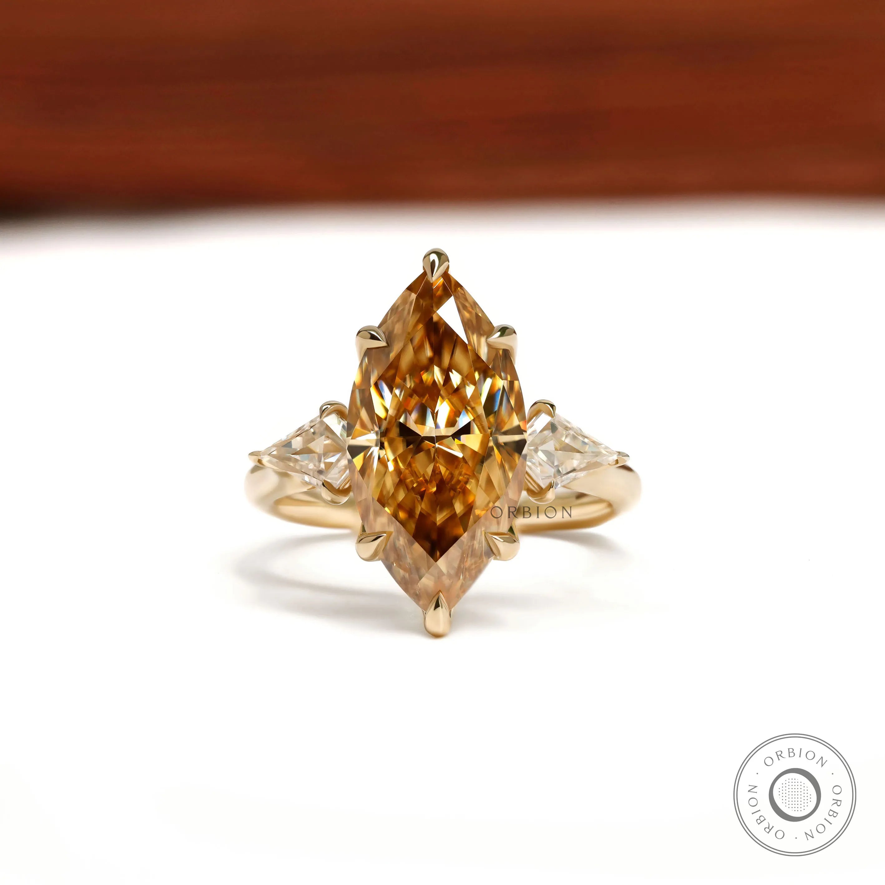 Marquise champagne three stone moissanite ring with tulip setting and kite side stones in 10k yellow gold