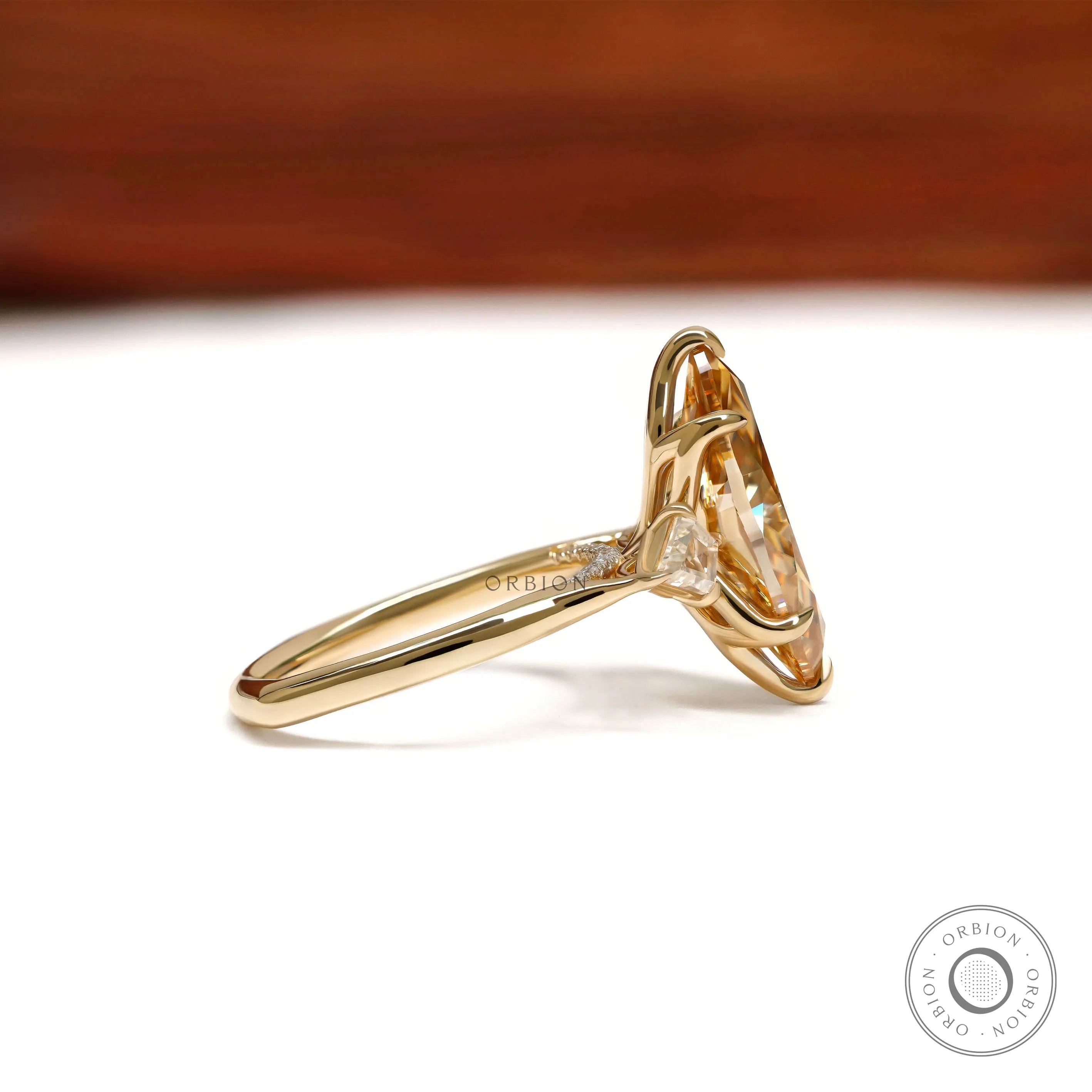 Marquise champagne moissanite three stone engagement ring with tulip set and kite accents in yellow gold