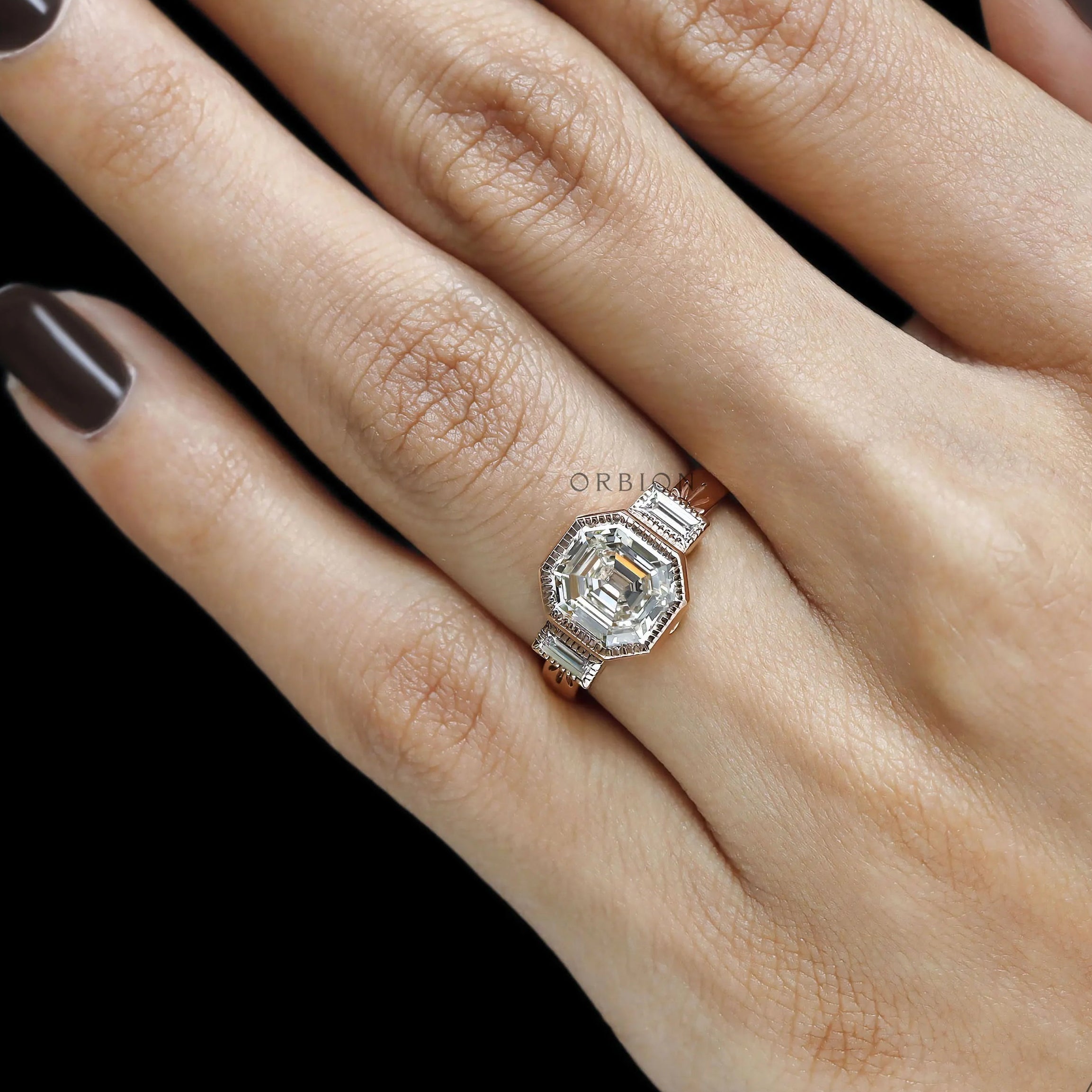 Rose gold art deco bridal ring featuring elongated asscher cut stone and baguette details