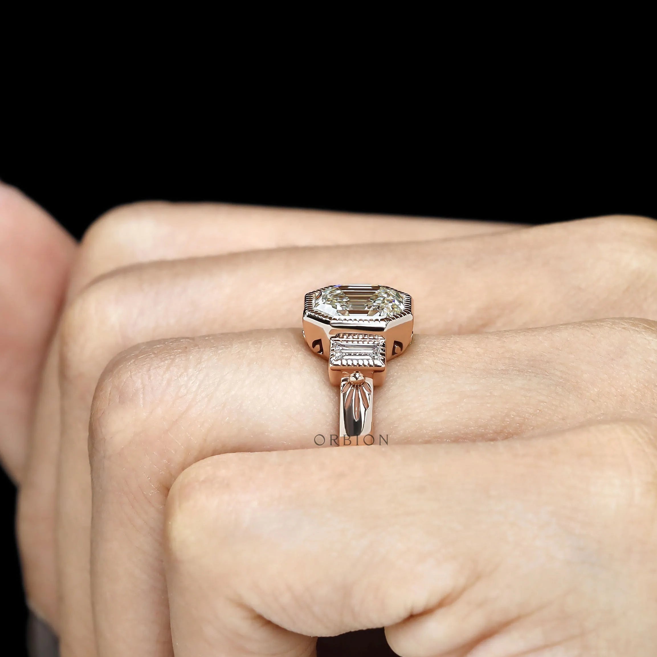 Bezel set three stone engagement ring with elongated asscher center and baguette accents