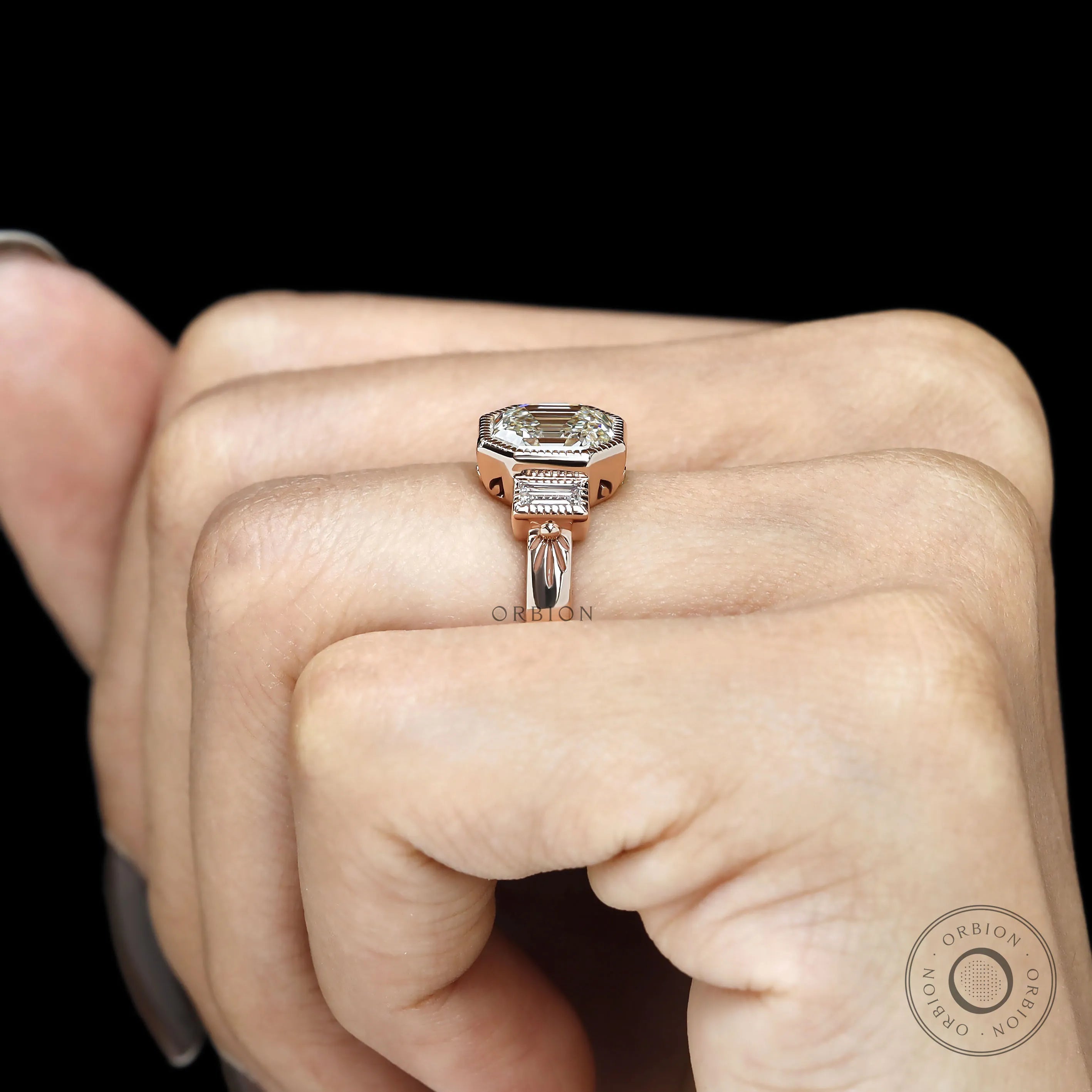 Bezel set three stone engagement ring with elongated asscher center and baguette accents