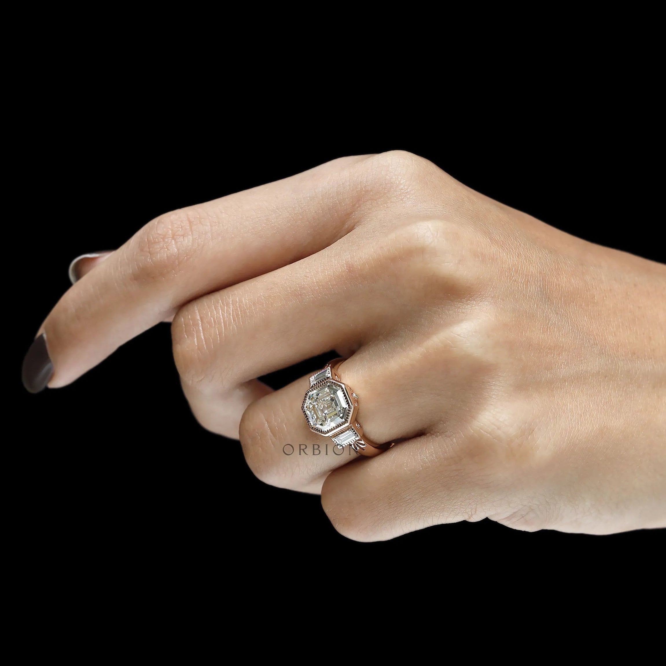 Art deco three stone ring featuring an elongated asscher center stone and baguette details
