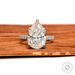 Pear solitaire moissanite engagement ring with pave split shank in white gold