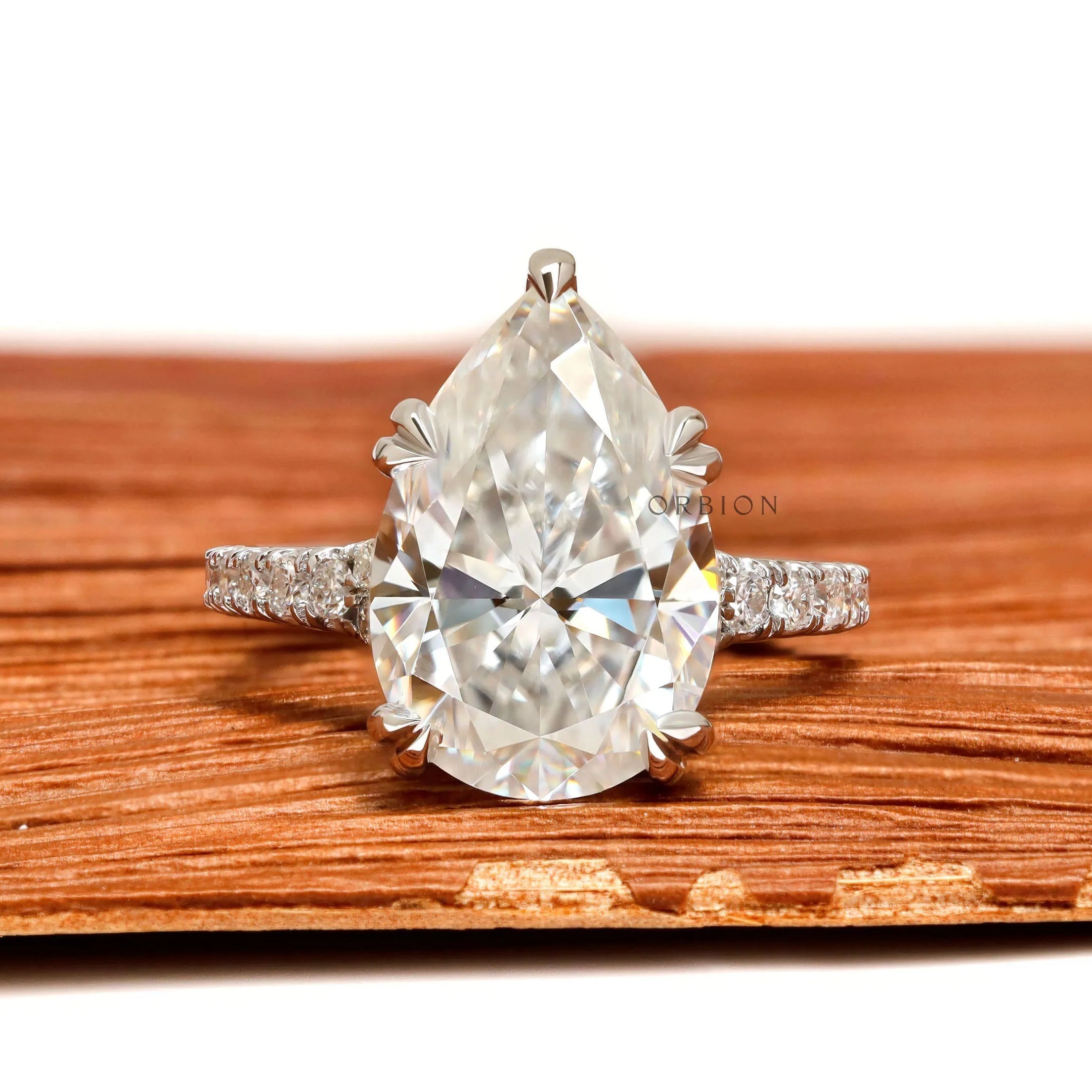 Pear solitaire moissanite engagement ring with pave split shank in white gold