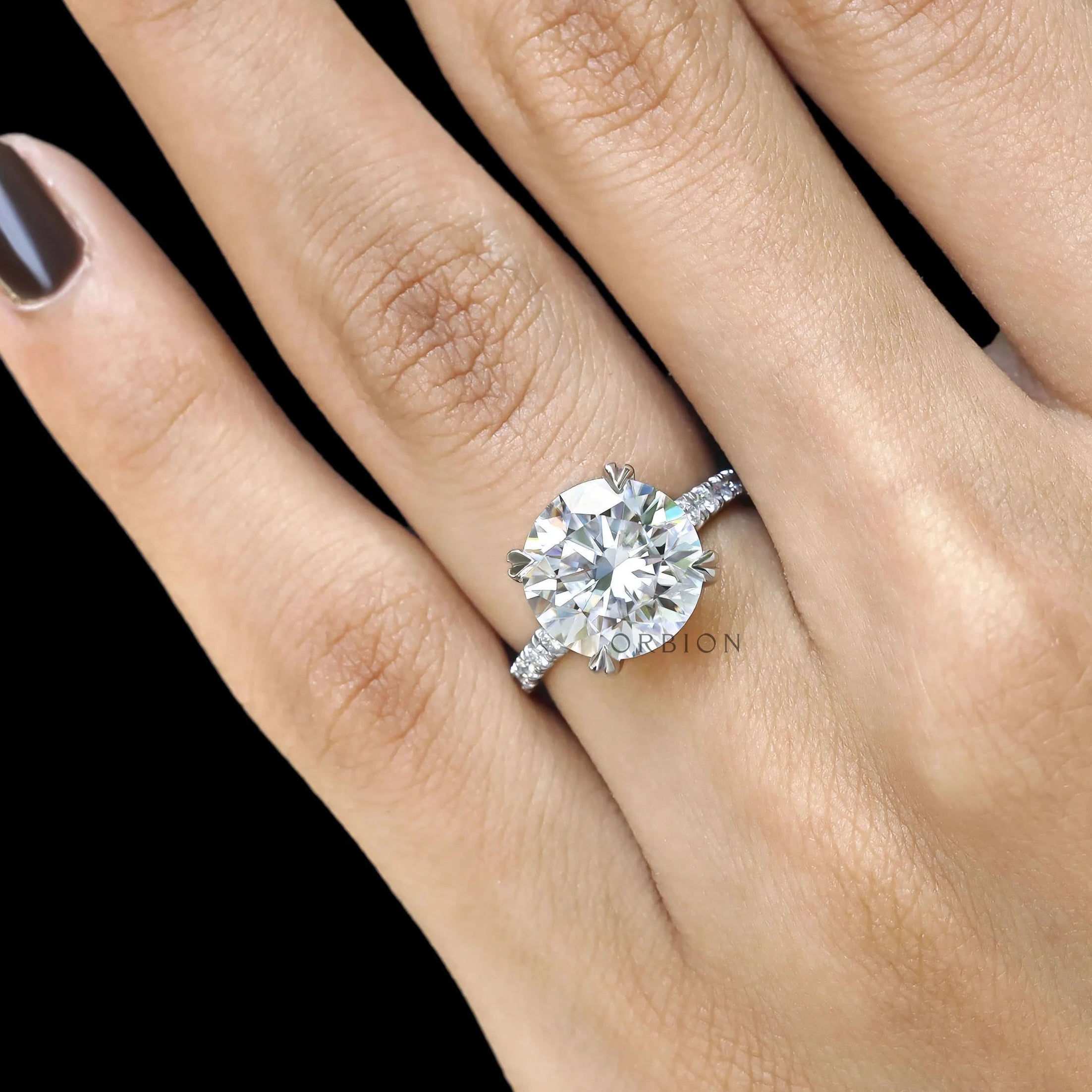 Elegant 10k white gold cathedral engagement ring with round moissanite and pave split shank