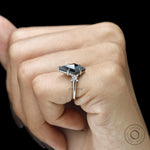 Gothic inspired platinum engagement ring with kite cut black moissanite and sparkling princess round stones
