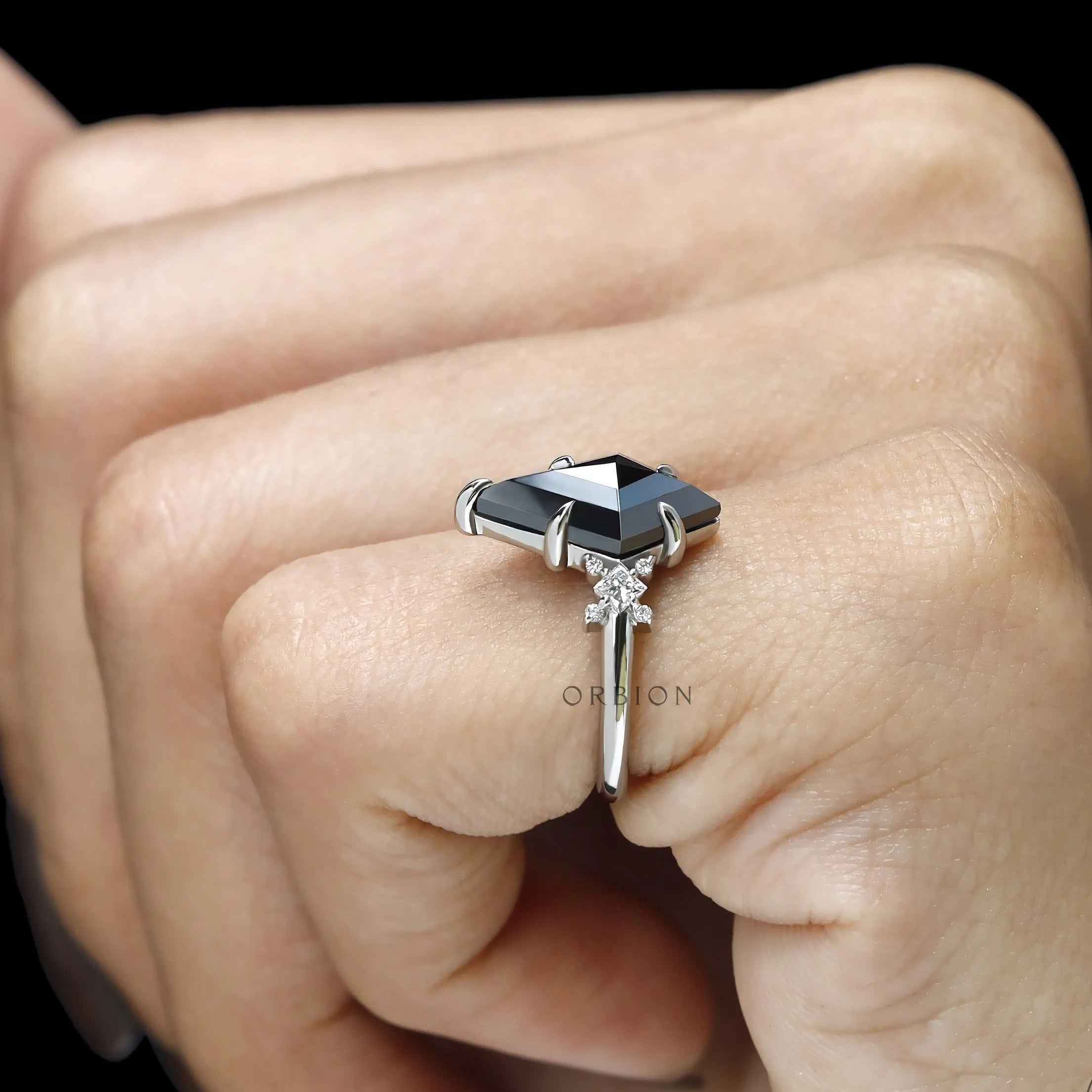 Gothic inspired platinum engagement ring with kite cut black moissanite and sparkling princess round stones