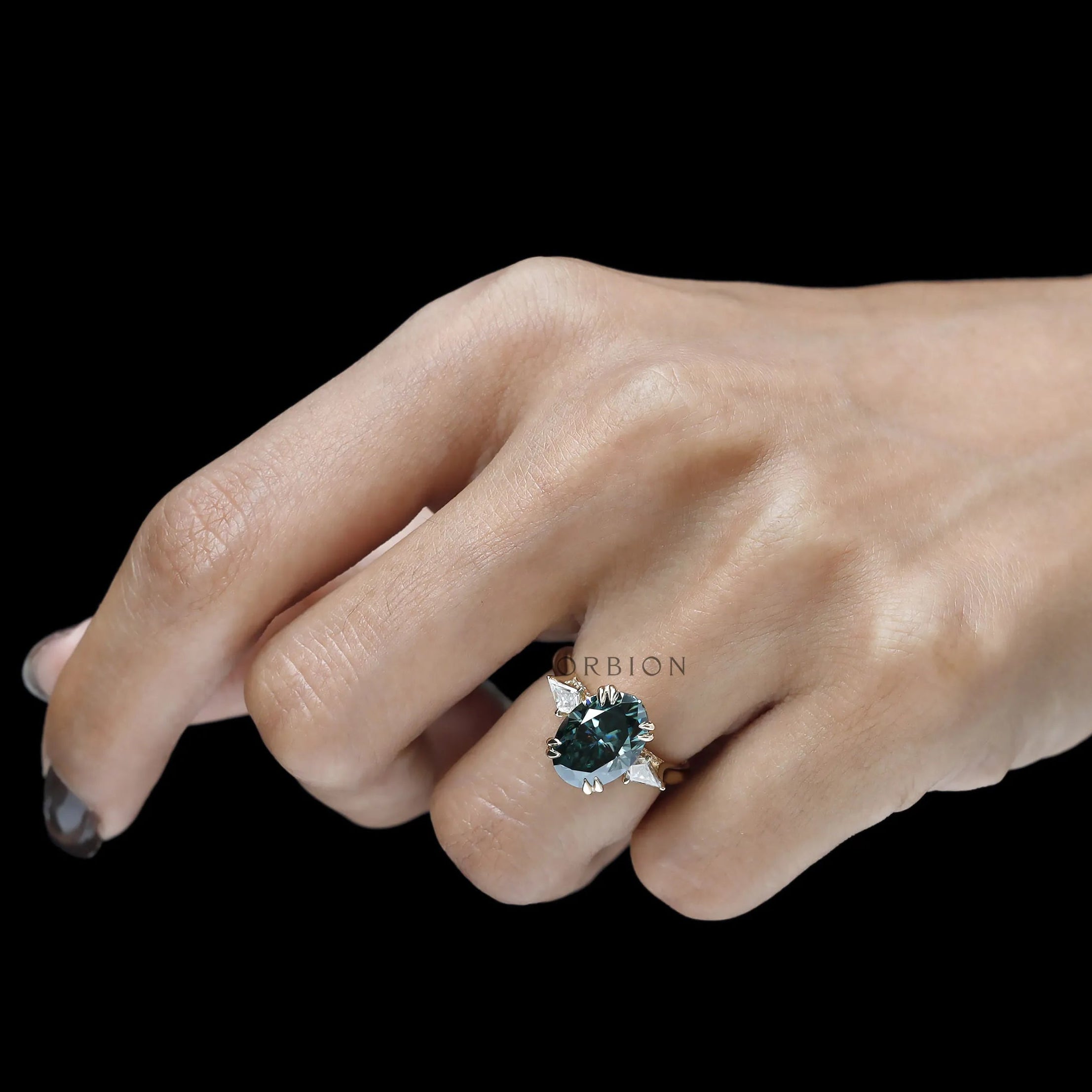 High profile engagement ring with oval blue green moissanite, three stones, kite accents and tulip setting