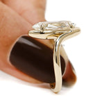 Unique bypass engagement ring featuring old mine cut lab diamond in moval shape with 14k yellow gold swirl band