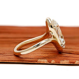 Elegant moval shaped lab grown diamond engagement ring with swirl band and vintage inspired yellow gold setting