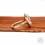 Elegant moval shaped lab grown diamond engagement ring with swirl band and vintage inspired yellow gold setting