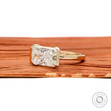 Modern radiant cut lab diamond or moissanite ring with horizontal east west setting and sleek yellow gold bezel