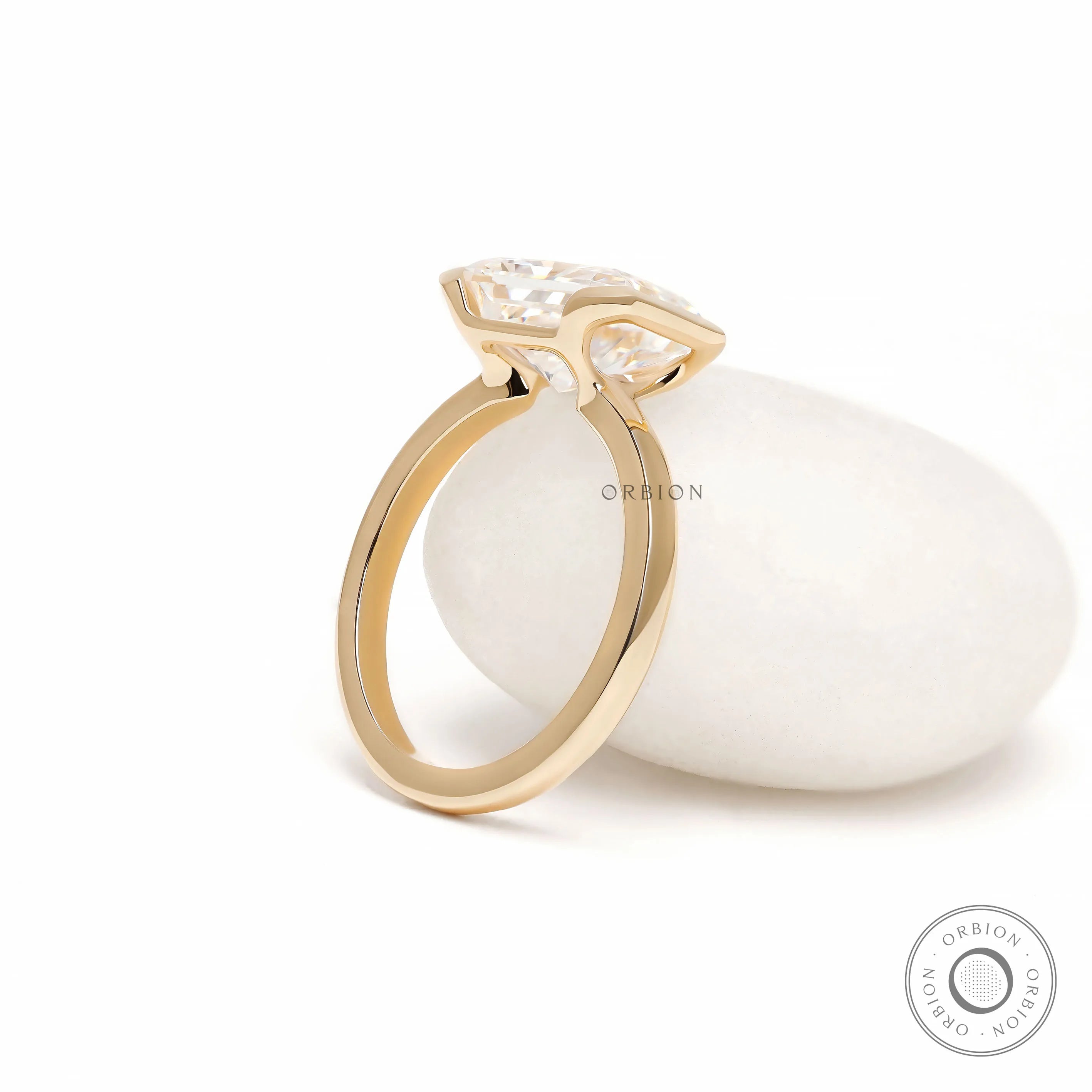 Minimalist radiant cut moissanite solitaire ring with east west orientation and contemporary half bezel design
