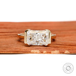 East west radiant cut moissanite or lab diamond engagement ring with sleek half bezel floating setting in 14k yellow gold