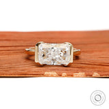 East west radiant cut moissanite or lab diamond engagement ring with sleek half bezel floating setting in 14k yellow gold
