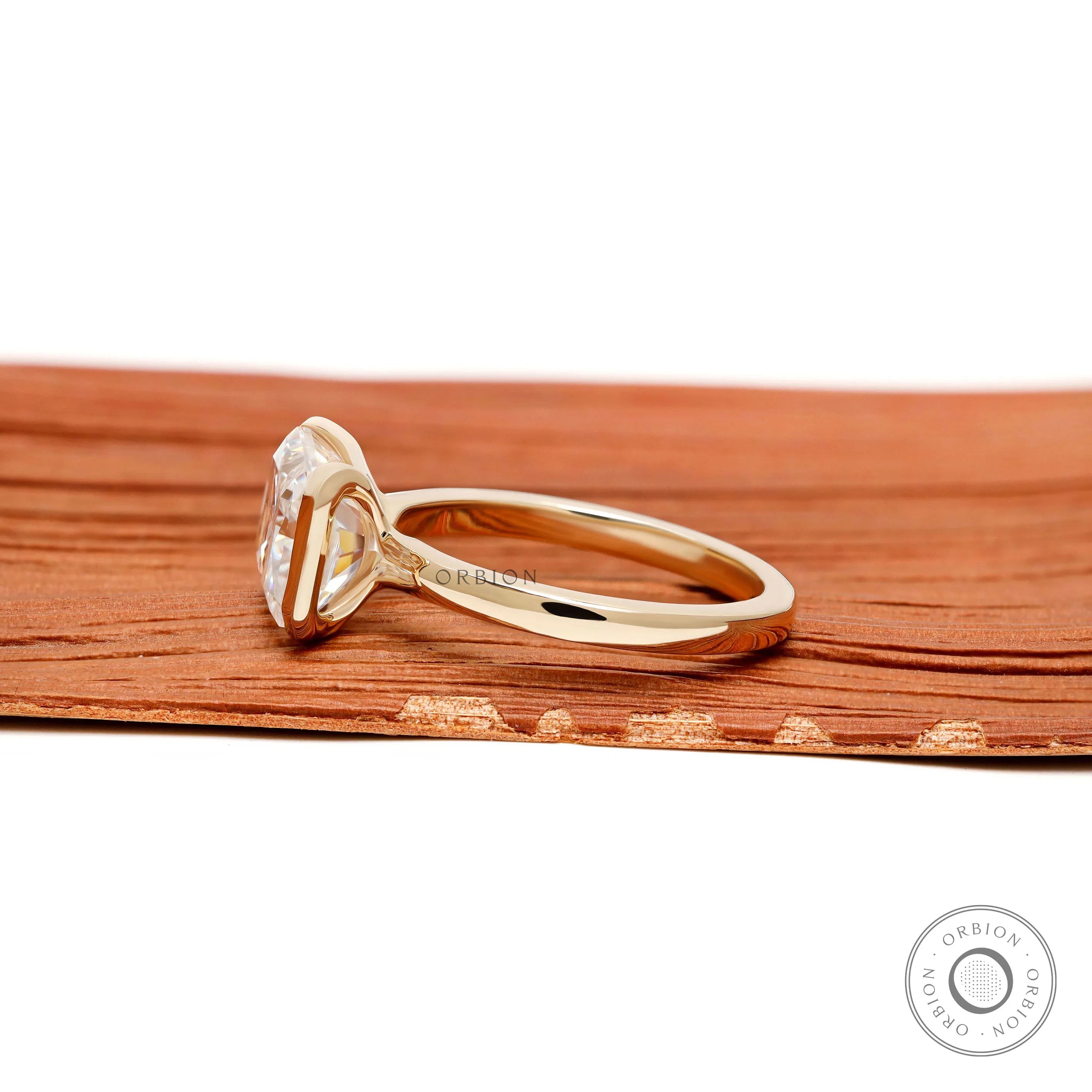 Elegant east west radiant cut engagement ring with floating half bezel setting in 14k yellow gold