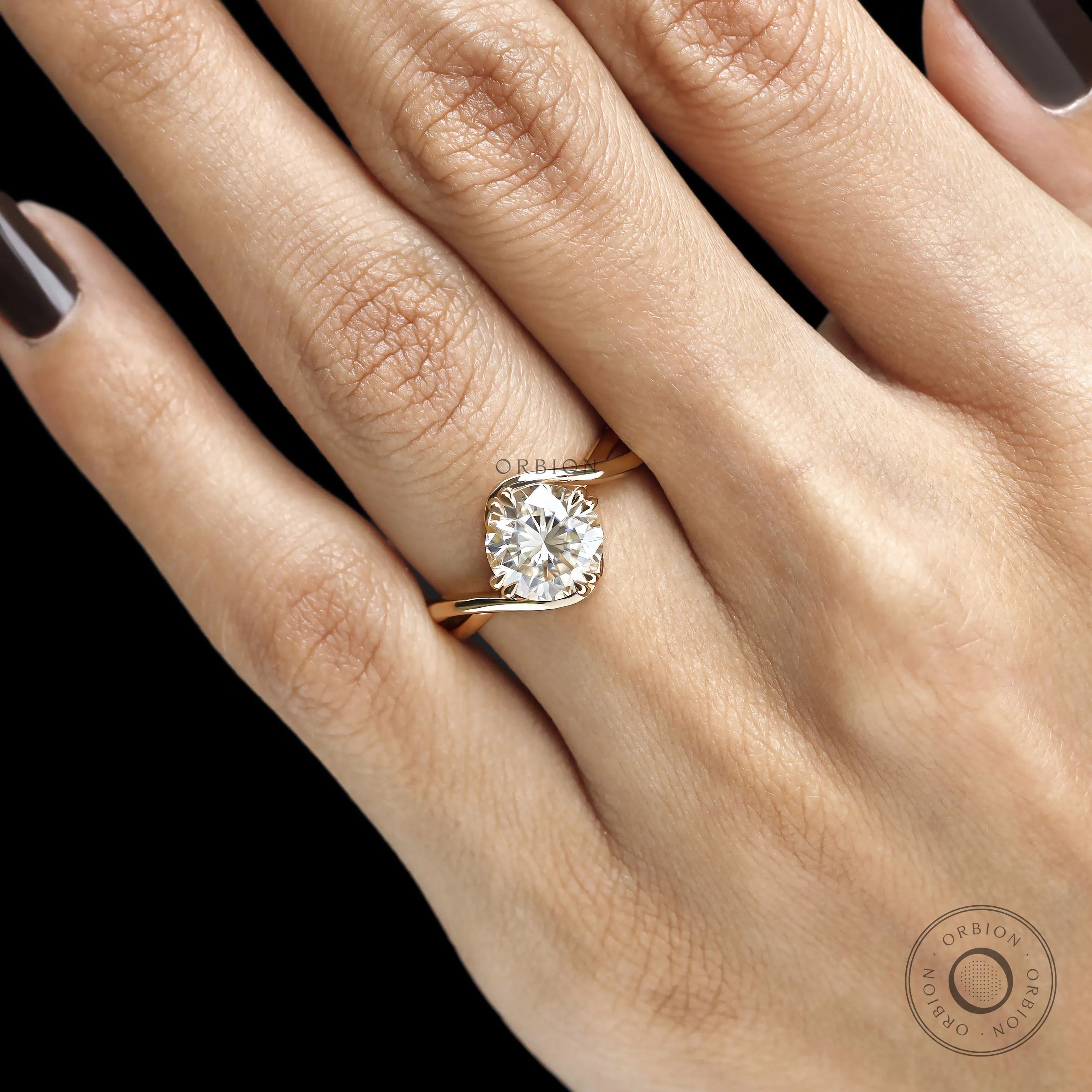 Fine jewelry bypass ring with round moissanite gemstone, compass setting, and curved crossover yellow gold band