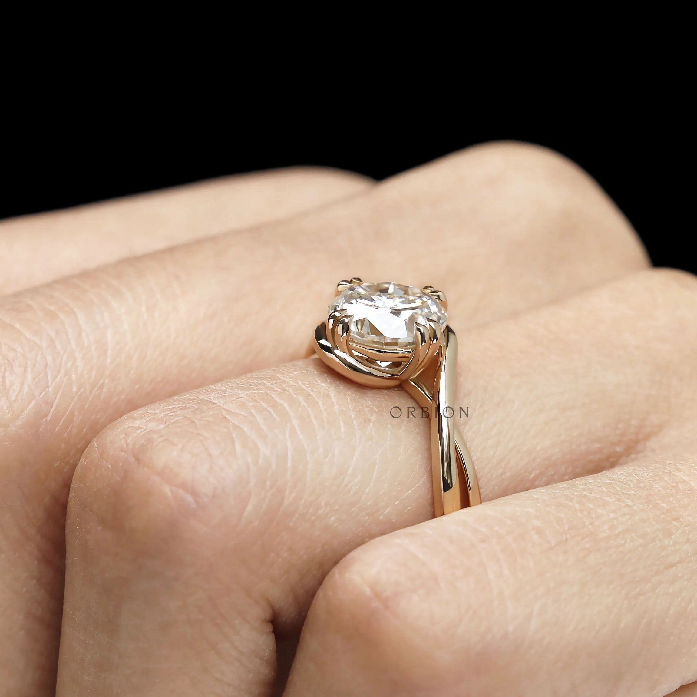 Lab diamond or moissanite crossover engagement ring featuring round cut stone and artistic swirl solitaire design