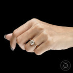 Round cut moissanite compass setting engagement ring with elegant swirl design in yellow gold