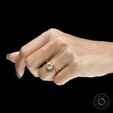 Round cut moissanite compass setting engagement ring with elegant swirl design in yellow gold