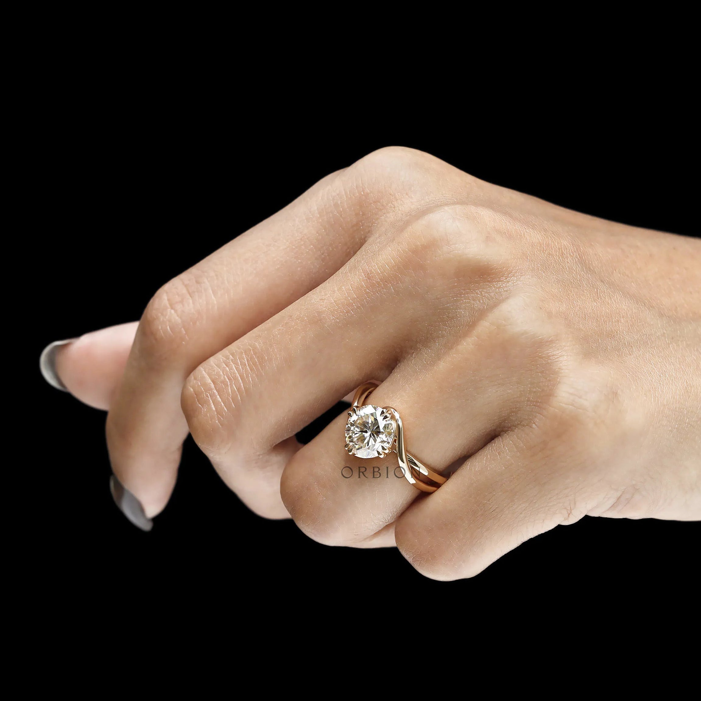 Round cut moissanite compass setting engagement ring with elegant swirl design in yellow gold