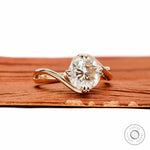 14k yellow gold swirl solitaire ring featuring round cut moissanite with unique crossover bypass design