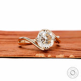 14k yellow gold swirl solitaire ring featuring round cut moissanite with unique crossover bypass design