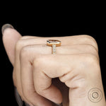 Women’s 18k gold bezel ring featuring pink diamond gemstone and intricate vintage leaf pattern