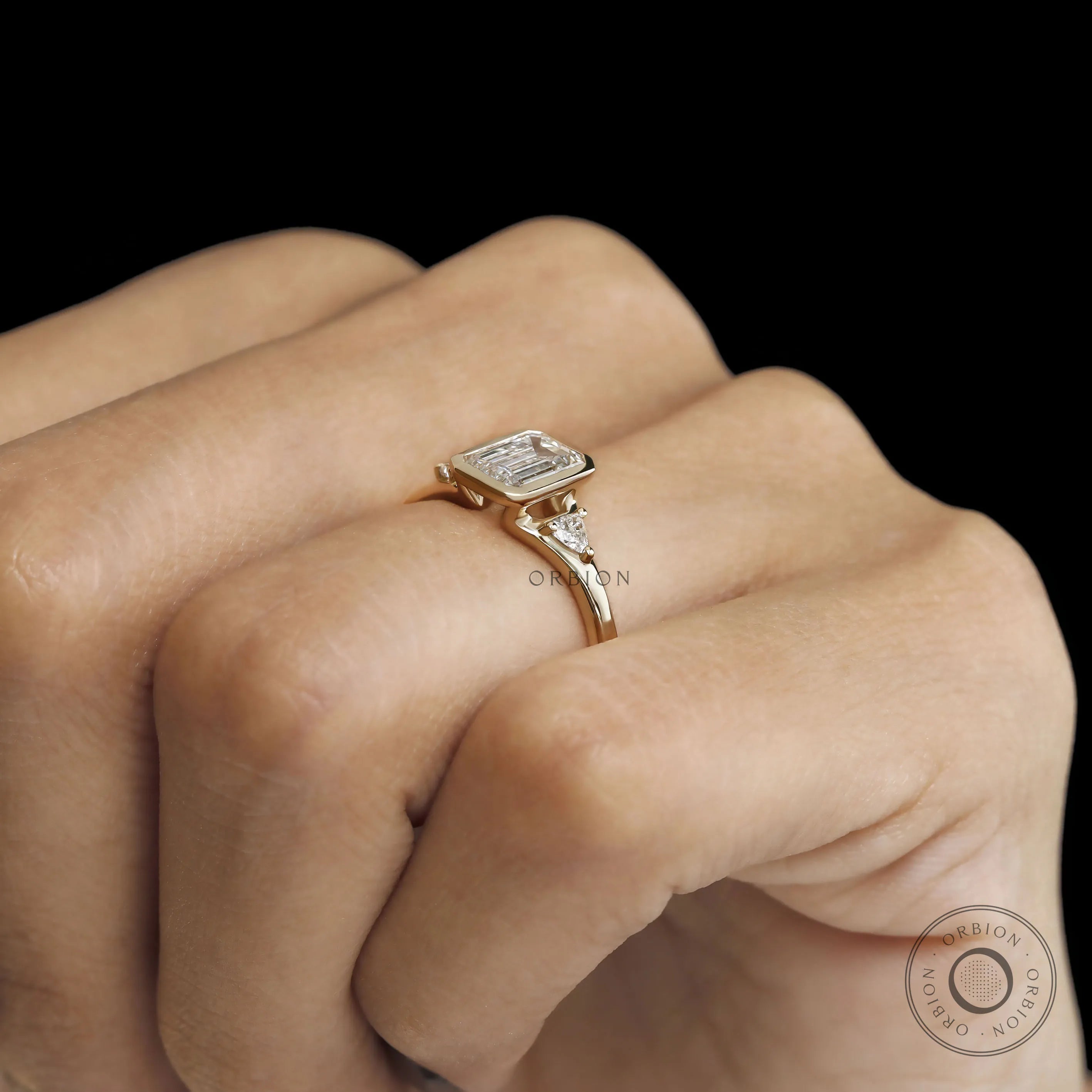 Sleek three stone emerald cut engagement ring featuring lab diamond or moissanite gemstones for women
