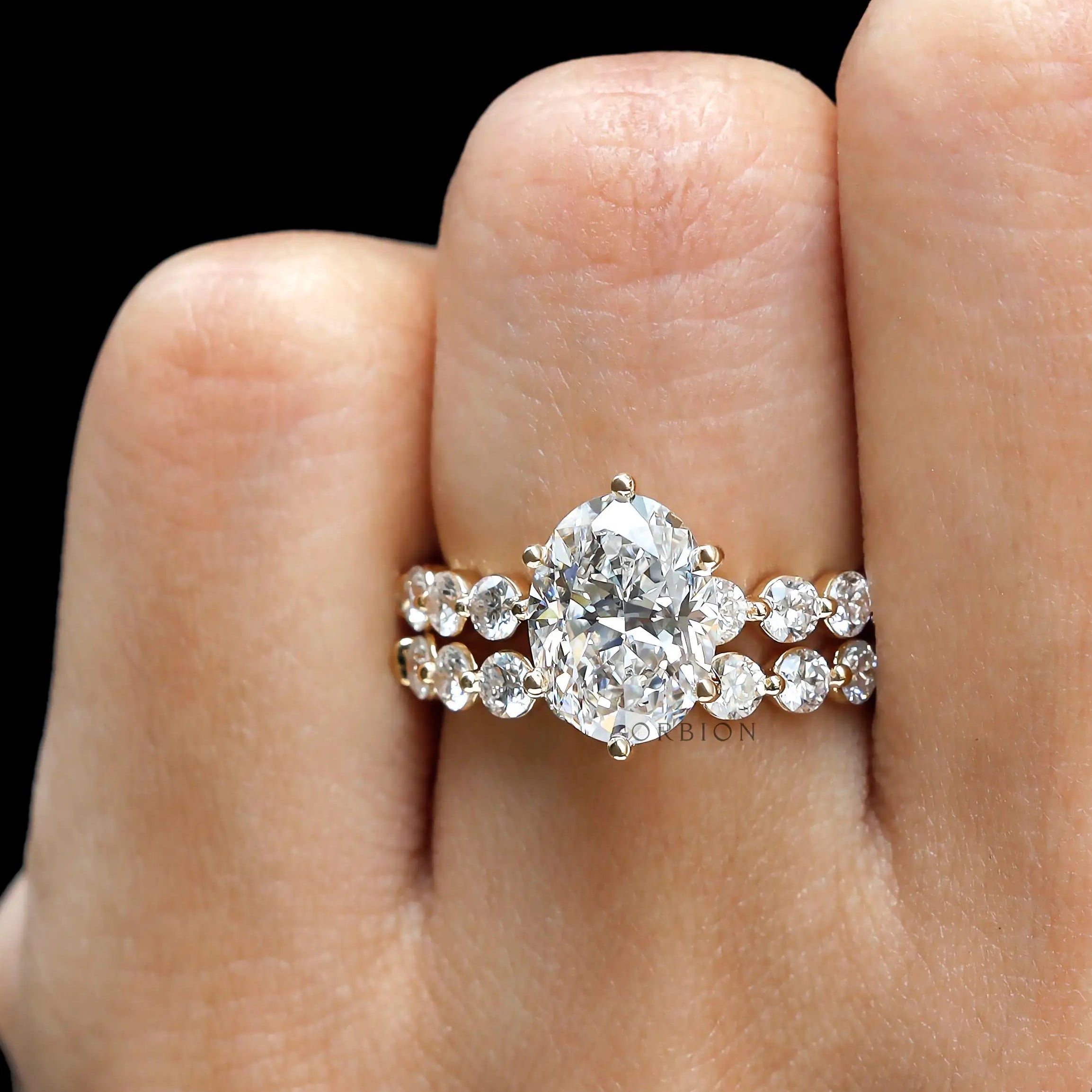 Straight on-hand view of oval lab diamond ring set with double shared prong bands in yellow gold