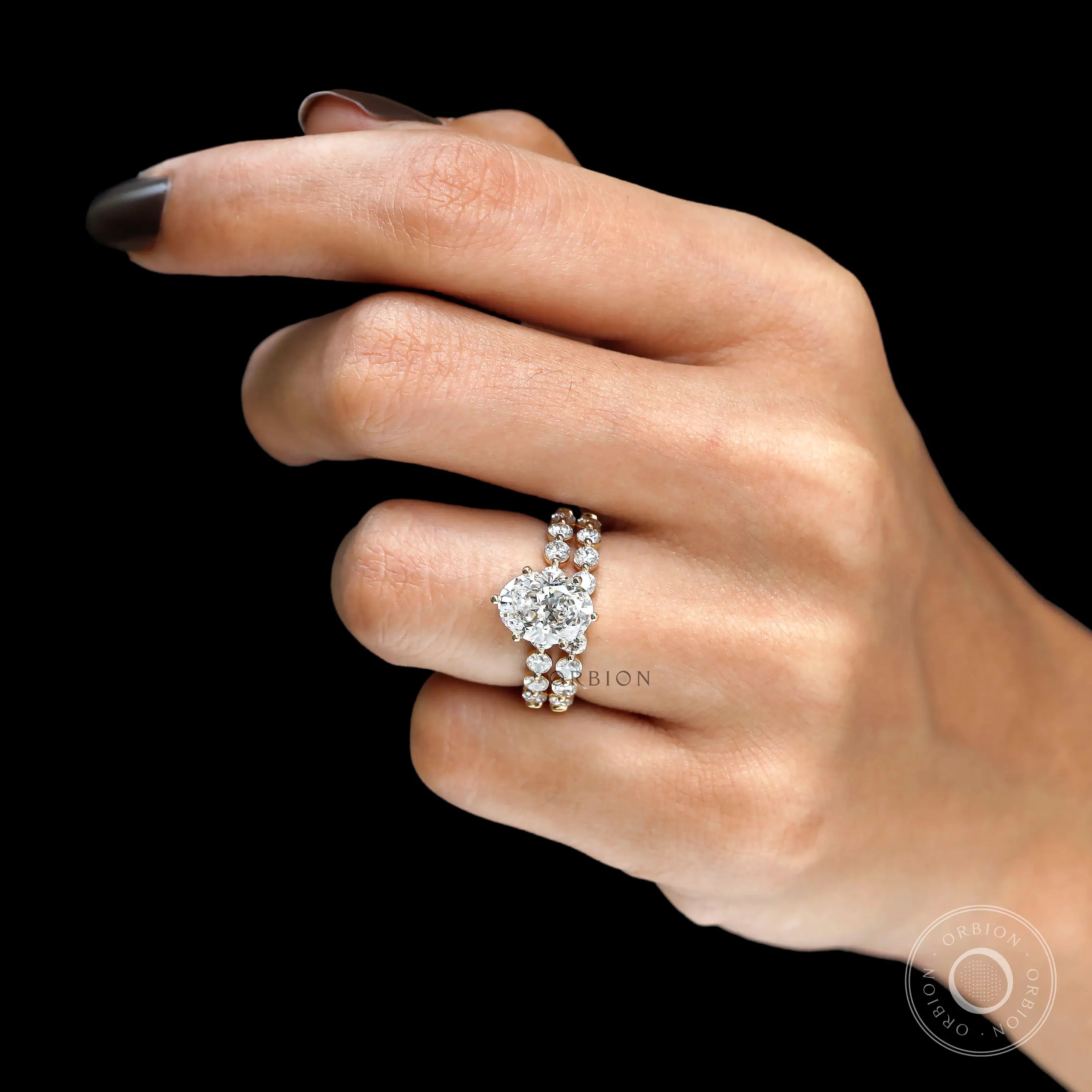 Full hand view of oval lab diamond bridal ring set with stacked shared prong band in yellow gold