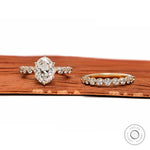 Flat display of oval lab diamond ring with shared prong band on surface