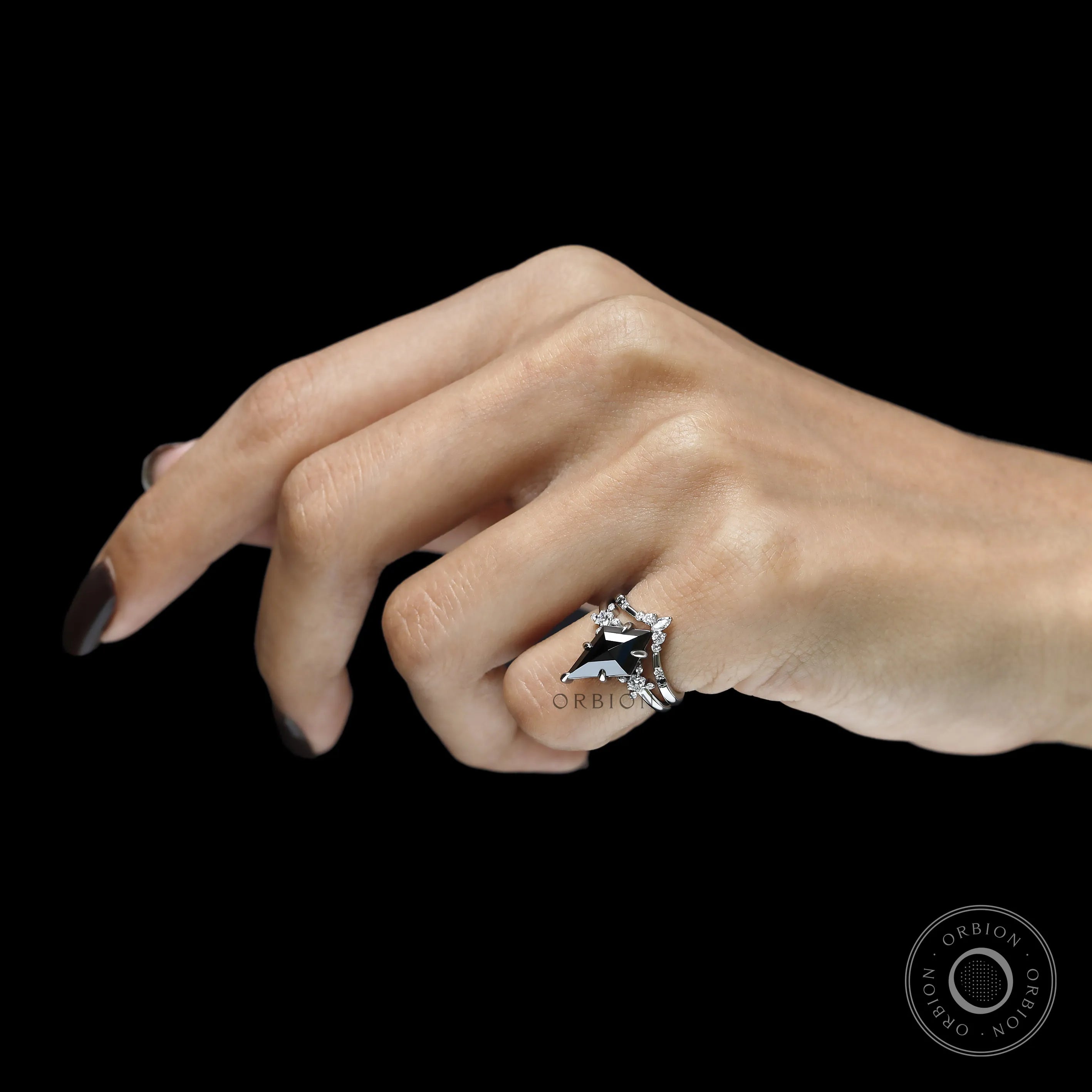Platinum solitaire engagement ring featuring kite cut black moissanite with chevron stacking band