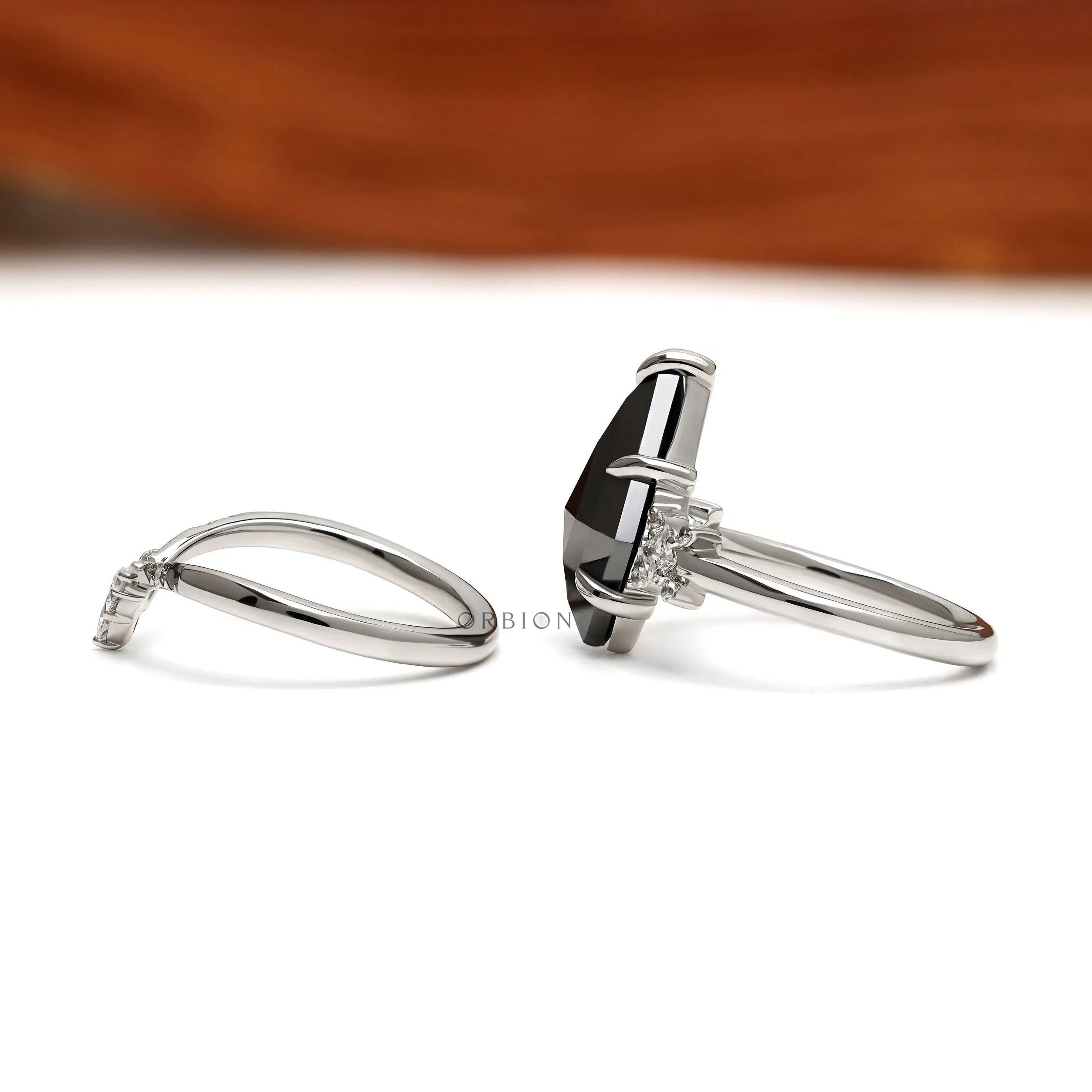 Unique kite cut black moissanite engagement ring with platinum setting and modern chevron stacking band