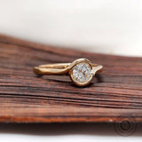Minimal round diamond solitaire ring on wooden surface