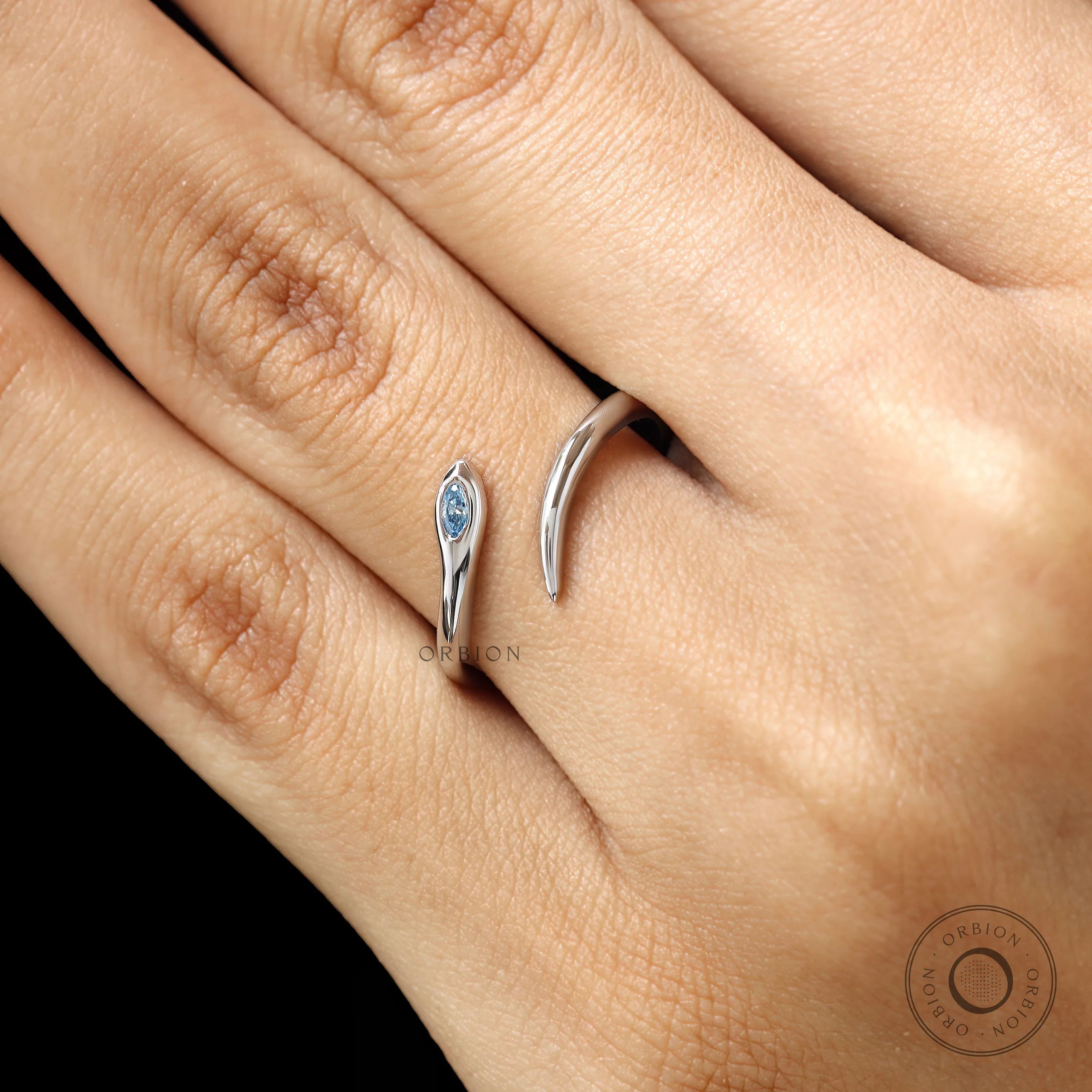 Contemporary lightweight snake ring in 14k white gold with blue diamond