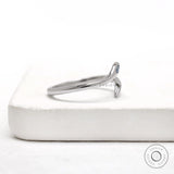 White gold open wrap snake ring featuring a flush set blue diamond