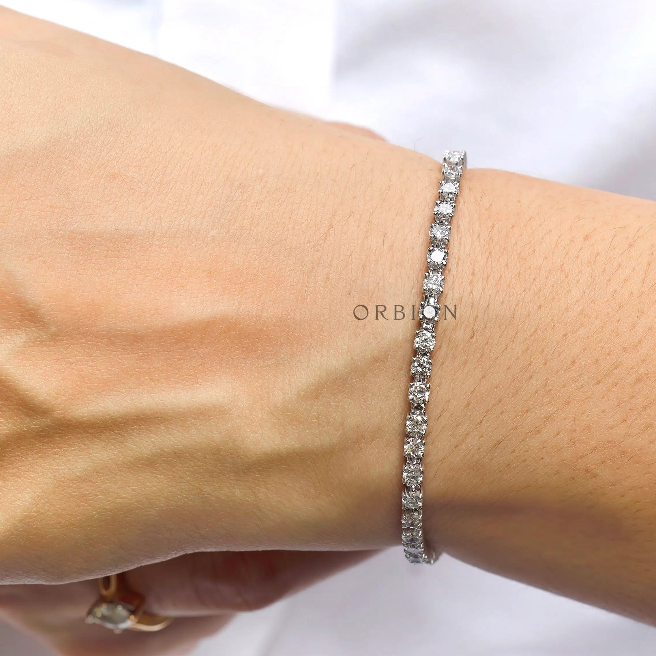 Round lab diamond tennis bracelet in 10K white gold on hand