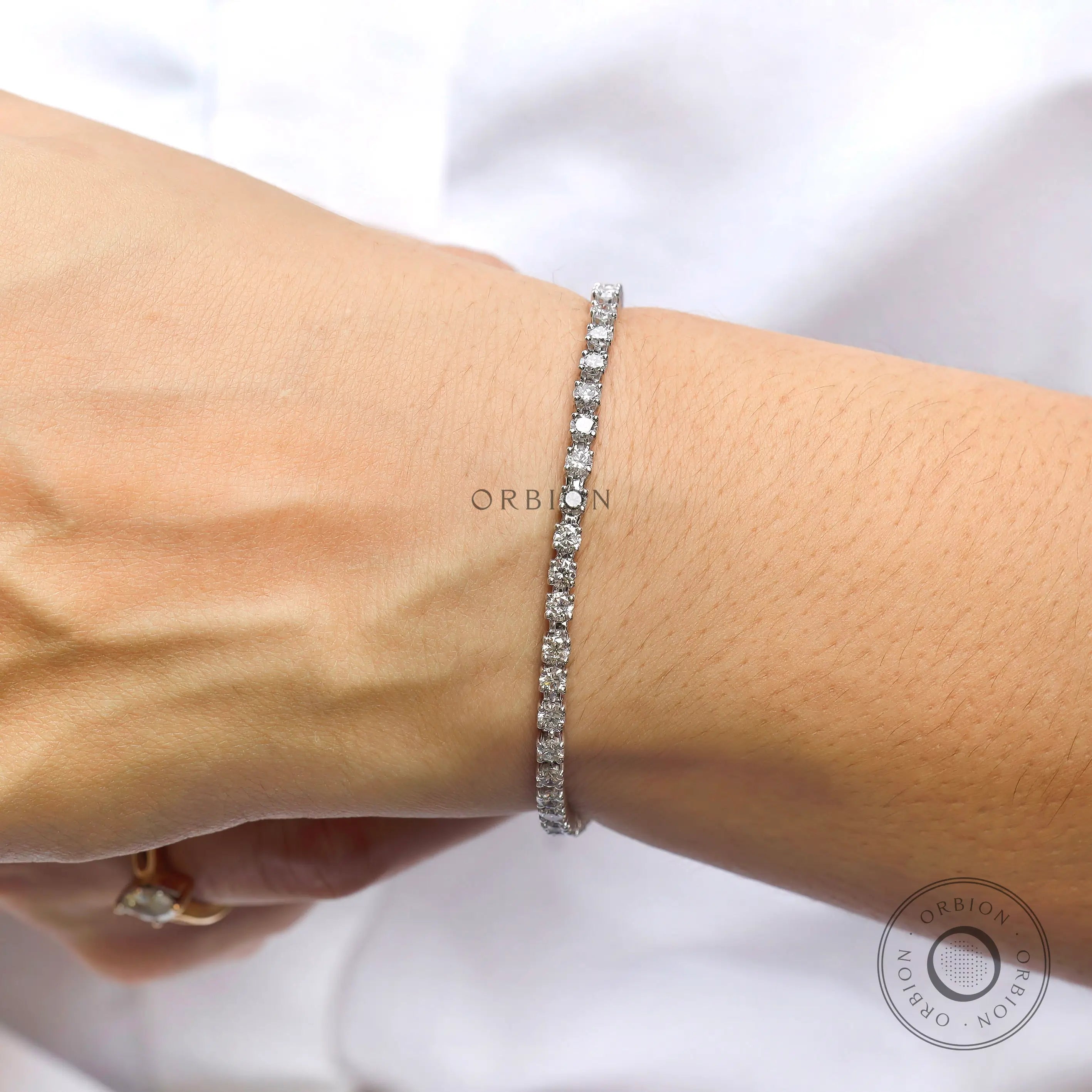 Round lab diamond tennis bracelet in 10K white gold on hand