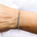 Round brilliant lab diamond tennis bracelet on wrist close-up