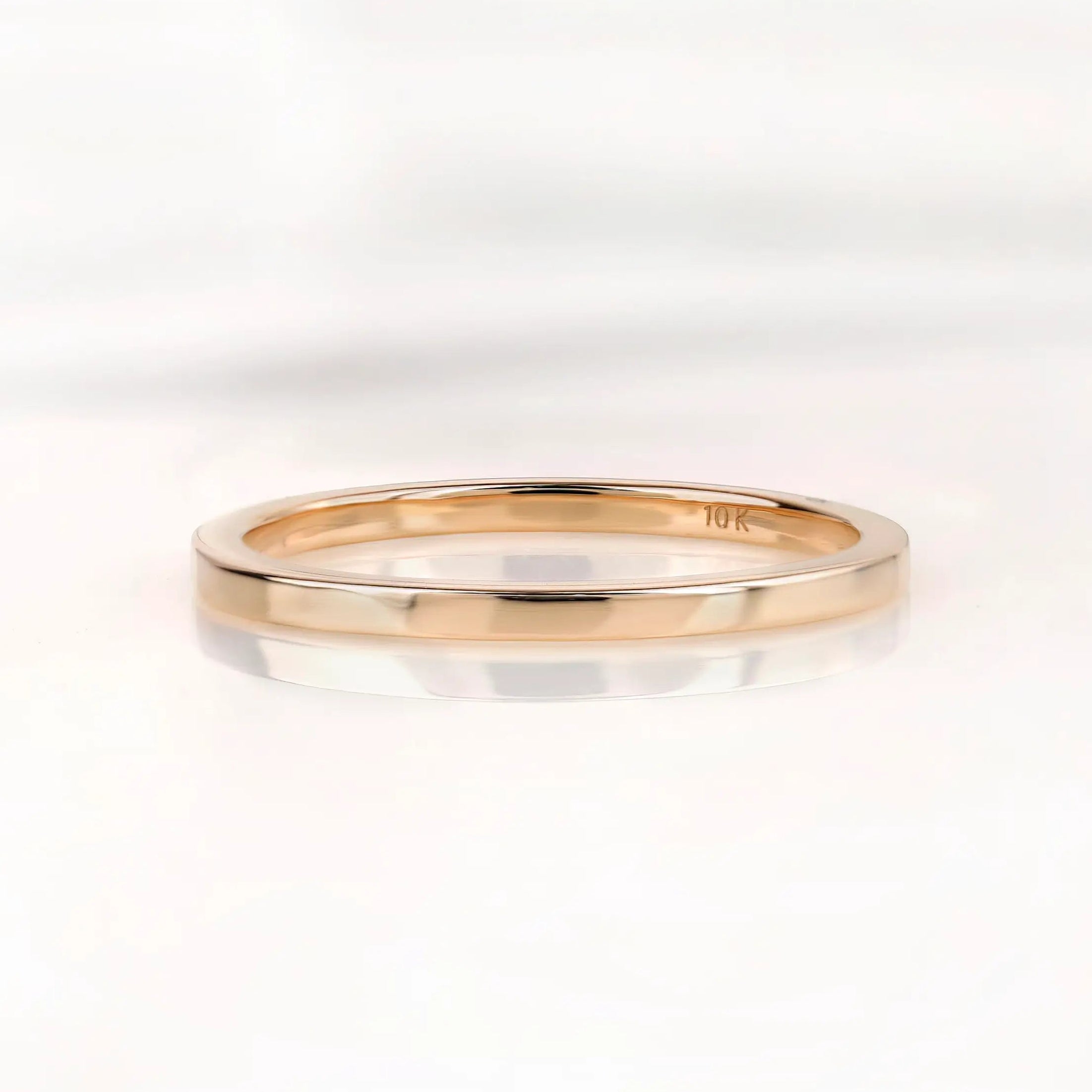 Slim polished gold wedding band shown from front on white background