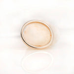 Minimal plain gold band photographed from top view on white surface