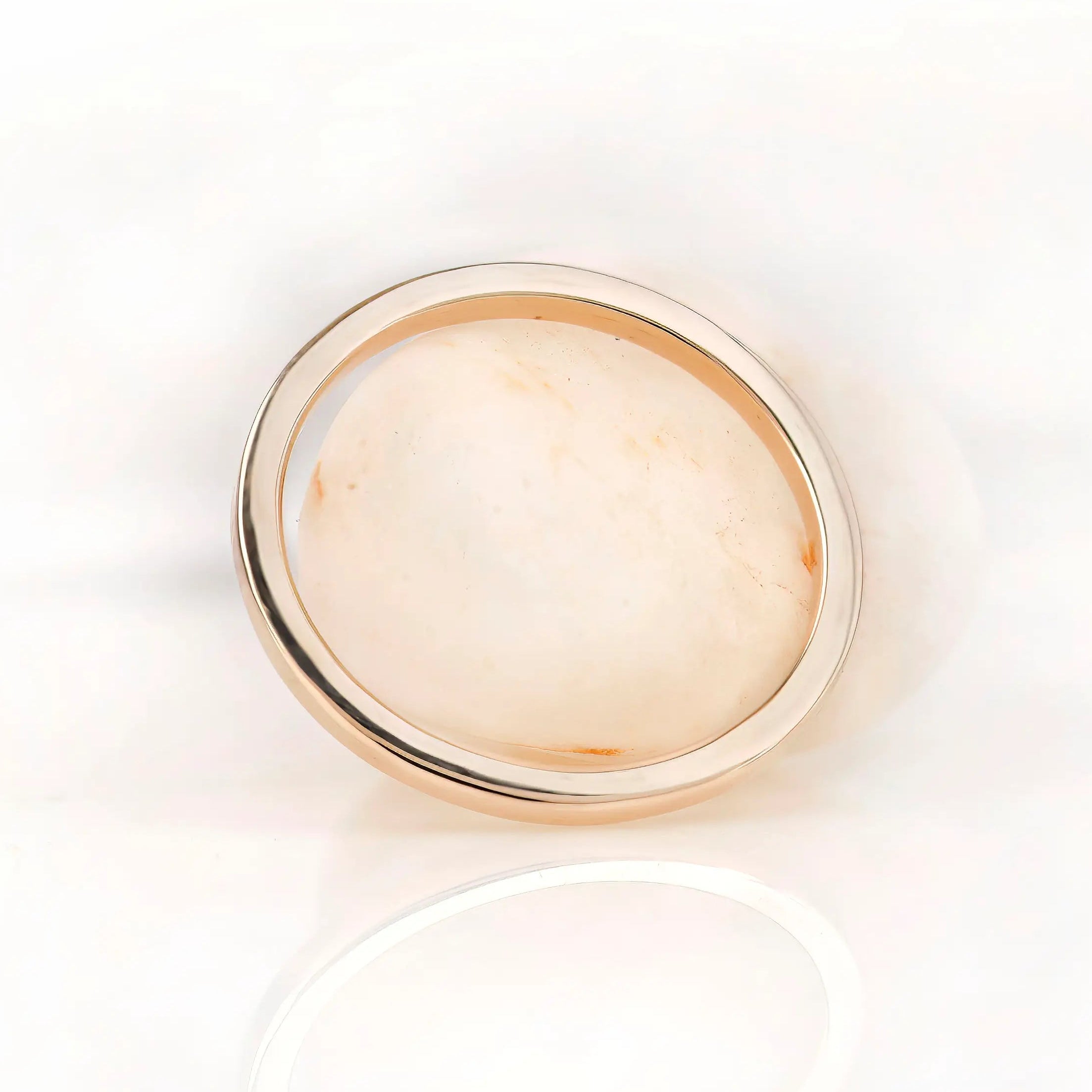 Minimal plain gold band photographed from top view on white surface