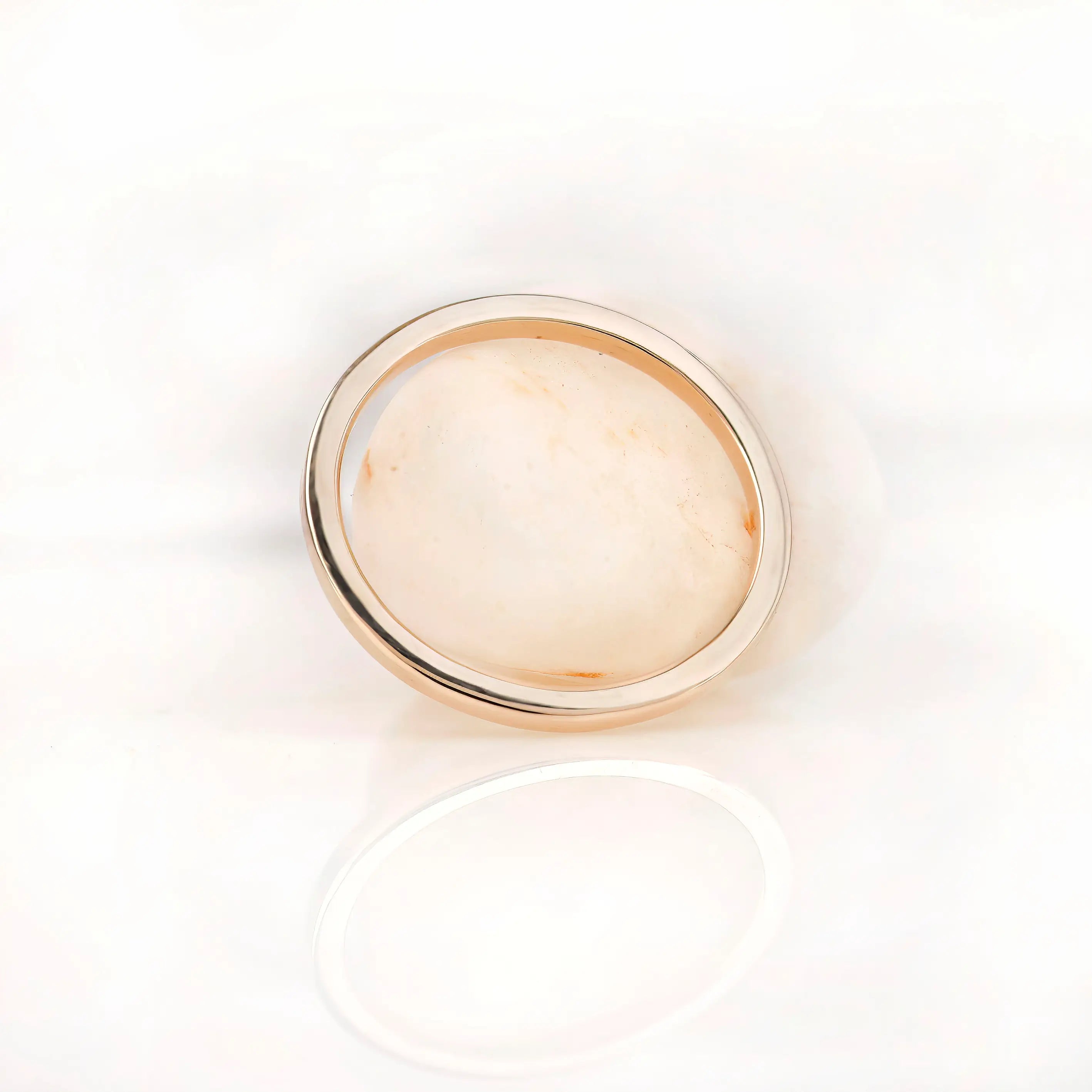 Minimal plain gold band photographed from top view on white surface