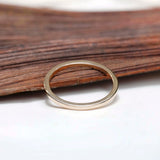 Polished gold band angled view resting on wooden background