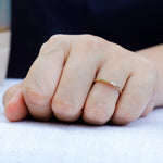 Simple gold wedding band showing circular profile worn on finger