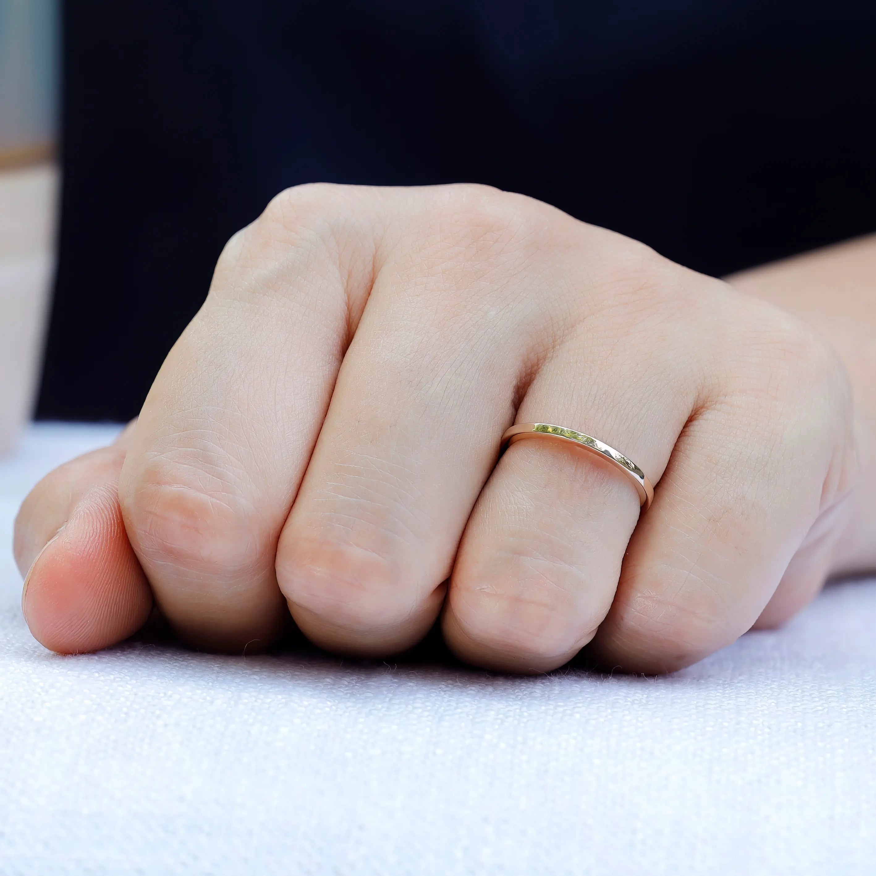 Simple gold wedding band showing circular profile worn on finger