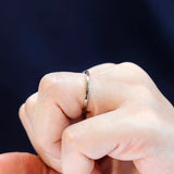 Close-up of thin polished gold wedding band worn on finger