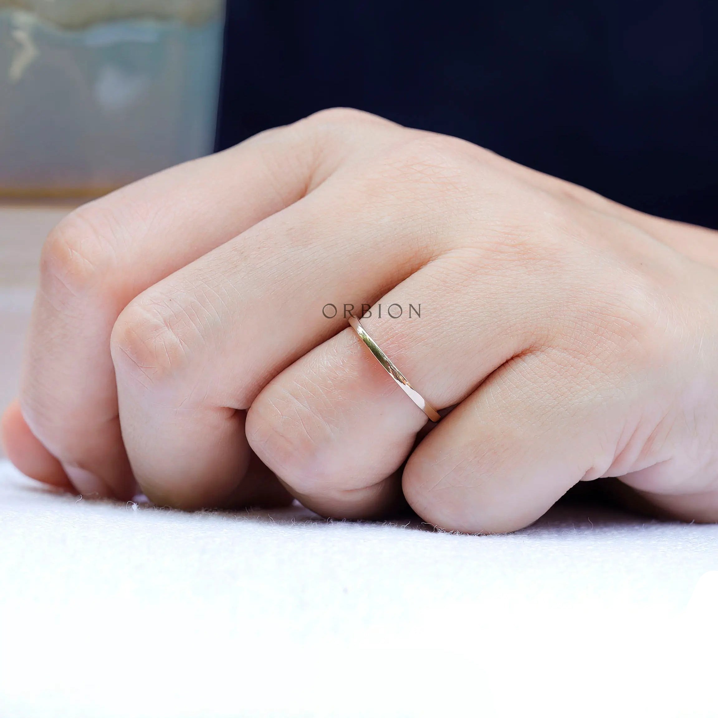 Slim gold band ring shown worn on finger for everyday minimalist styling